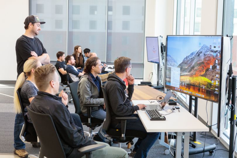 Pluralsight team members gather around a computer.